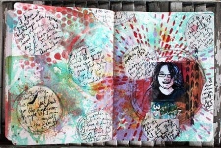 An artistic journal/scrapbook with cursive writing, jewel-tone background, and a cartoons self-portrait