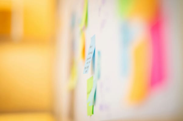An artistically focused photo of multi-colored post-it notes on a white wall