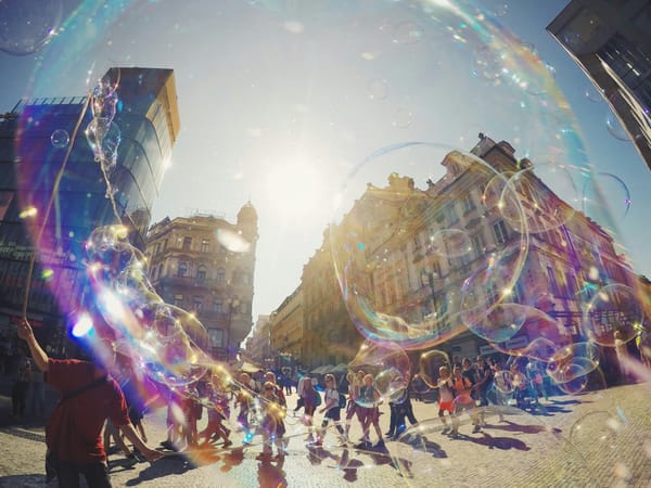 People on street watching artist forming huge bubbles