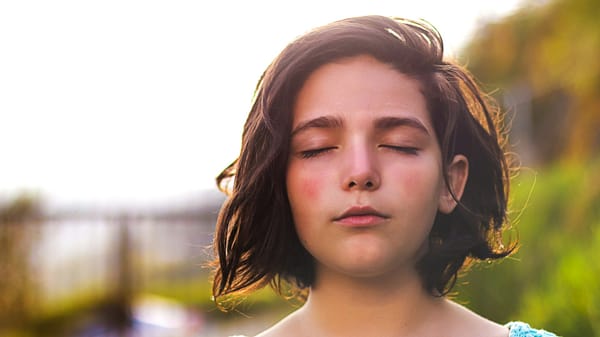 A young girl with her eyes closed